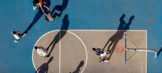 Young man and woman playing basketball, aerial view